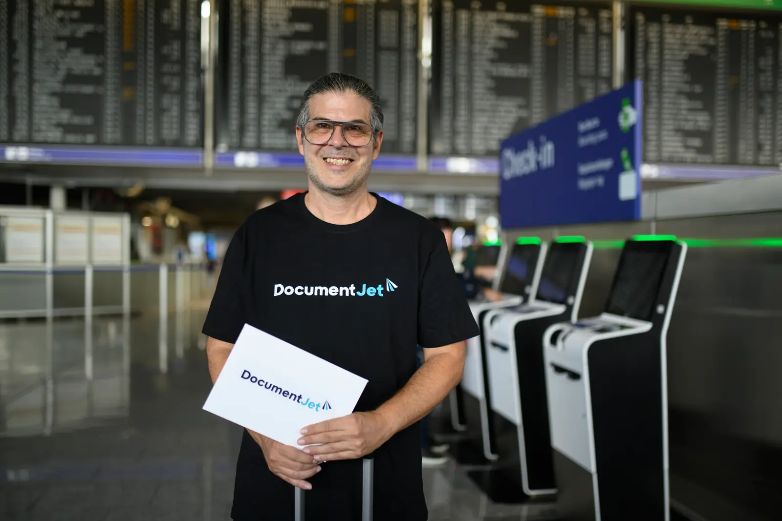 Coursier aérien DocumentJet tenant une enveloppe à documents à l’enregistrement de l’aéroport