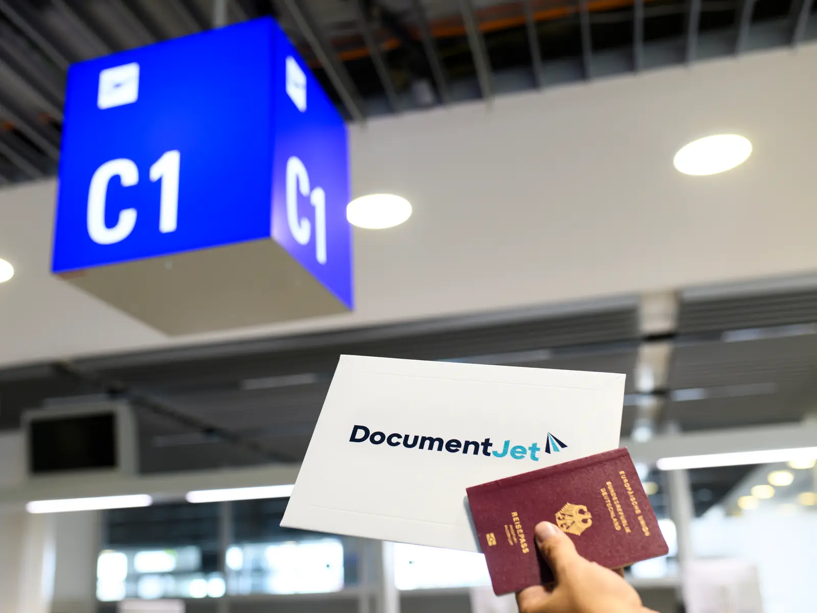 Passport and DocumentJet envelope held up at an airport gate