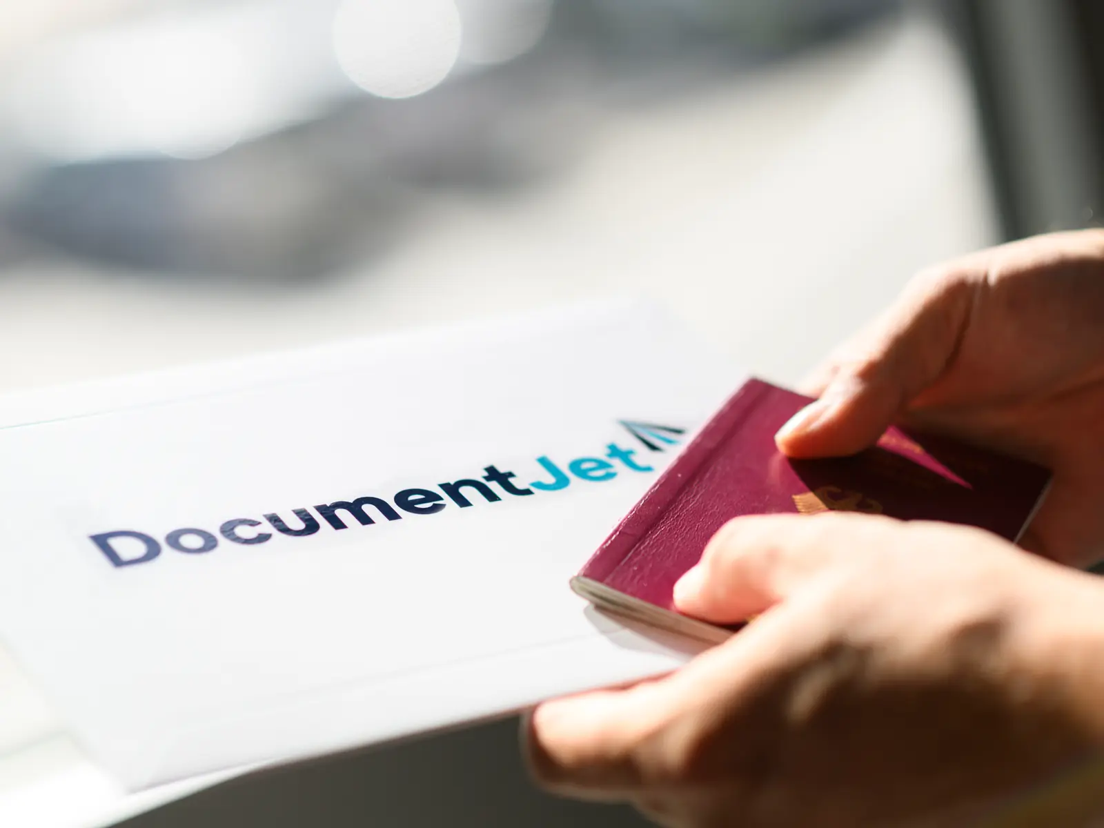 Mani che inseriscono un passaporto in una busta DocumentJet